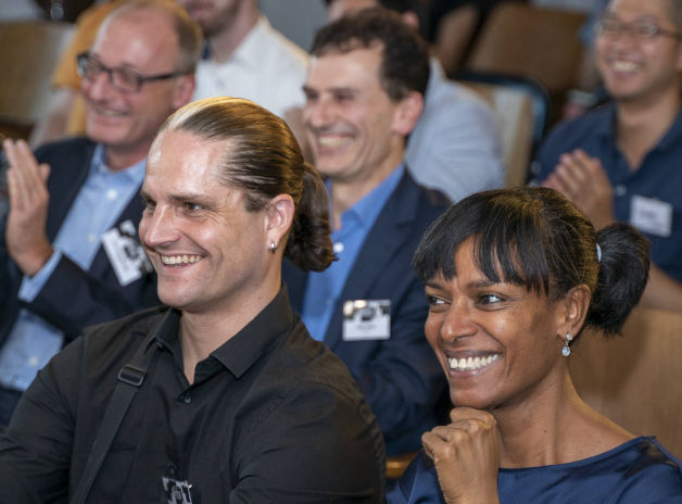 Ein Mann und eine Frau sitzen im Publikum und lachen.