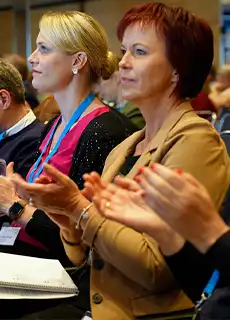 Zwei Frauen im Publikum applaudieren.